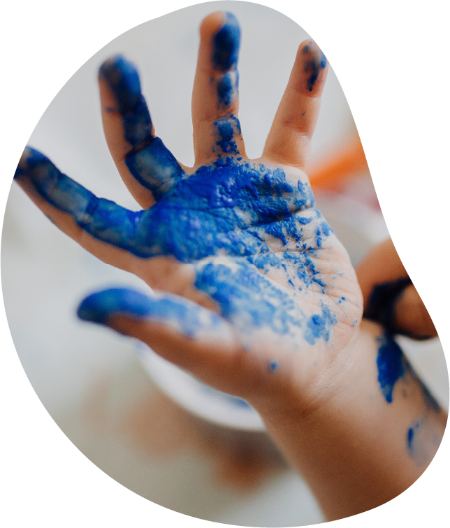 A child's hand with blue paint on it